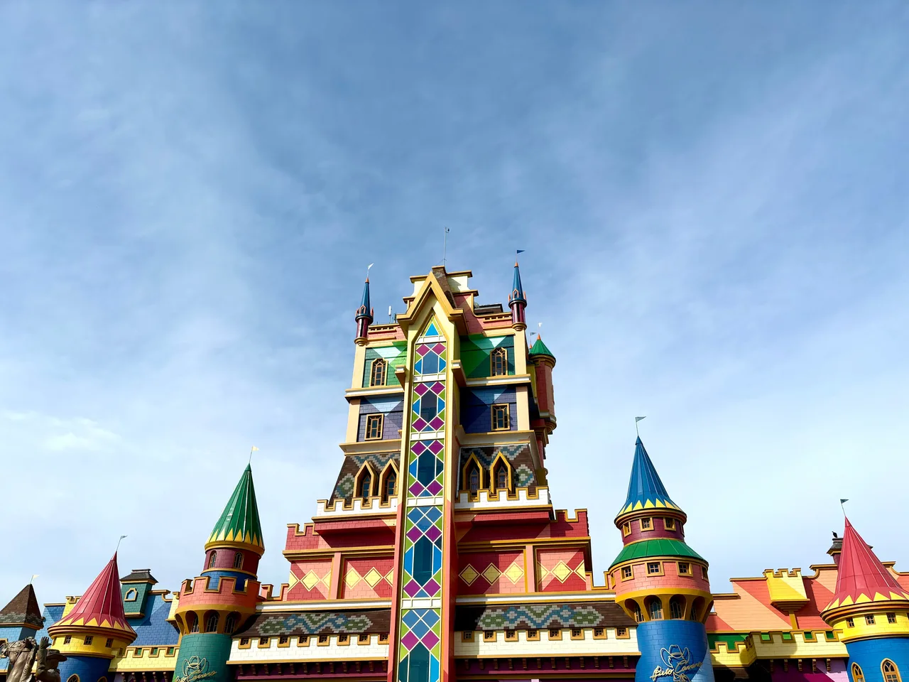 Castelo colorido do Beto Carrero World visto de baixo, com as torres contra o céu