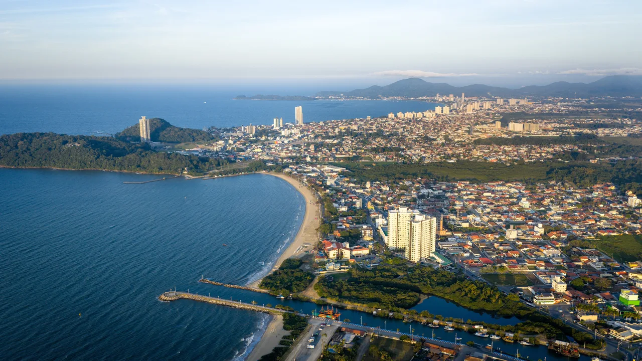 Vista aérea da praia de Balneário Piçarras, com o molhe, a faixa de areia e a cidade ao fundo