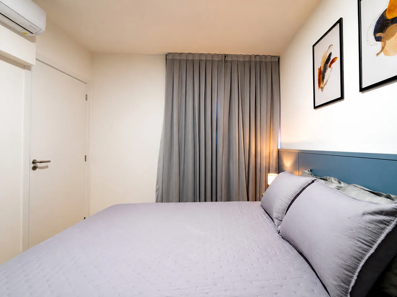 Quarto 1 visto da porta, com ar-condicionado e cortina até o chão