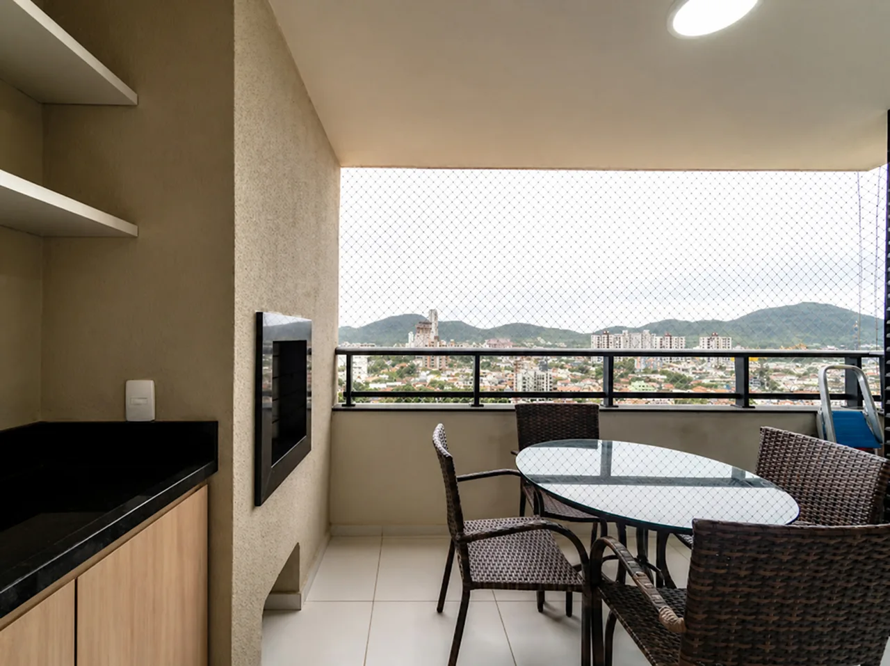 Varanda vista de dentro, com a cidade de Penha e os morros ao fundo